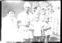 Three women standing with a group of children.