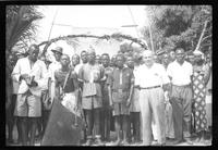 Missionary standing with a group of men and women.