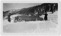 Edith Millican and a man shoveling a car out of snow.