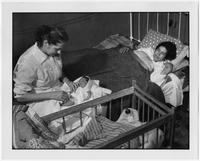 Myrtle Scott attending to an infant.