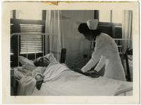 Nurse aiding blind patient.
