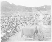 Chaplain Harold Voelkel holding religious service for North Korean captives, June 26, 1952.