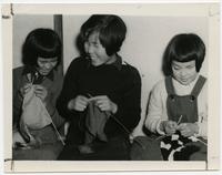 Three blind girls learning to knit.