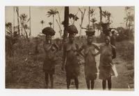 Four women carrying baskets on their heads.