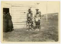 Two Native American men in tribal clothing.