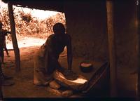 Muluba woman grinding corn.