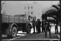 Group of men standing next to a truck.